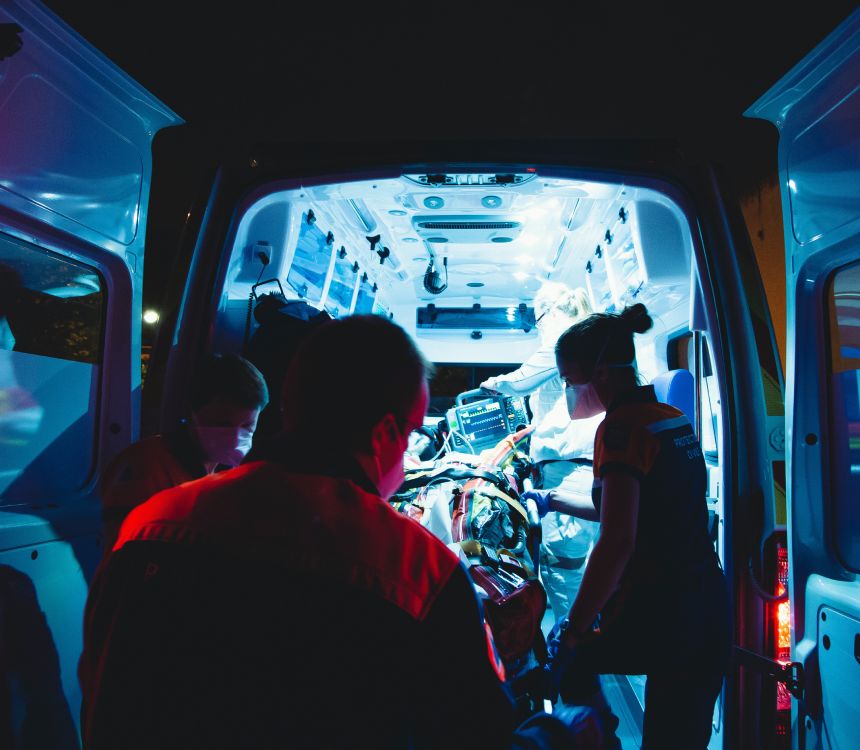A group of people standing inside of an ambulance.