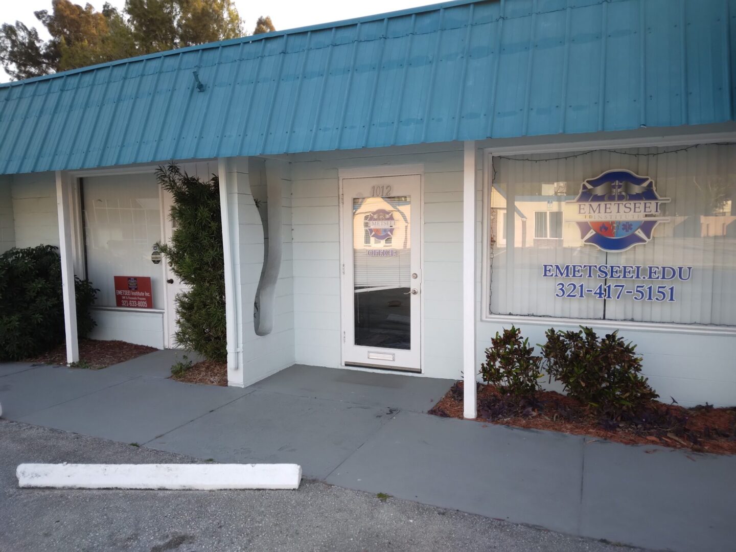 A blue and white building with a door open.